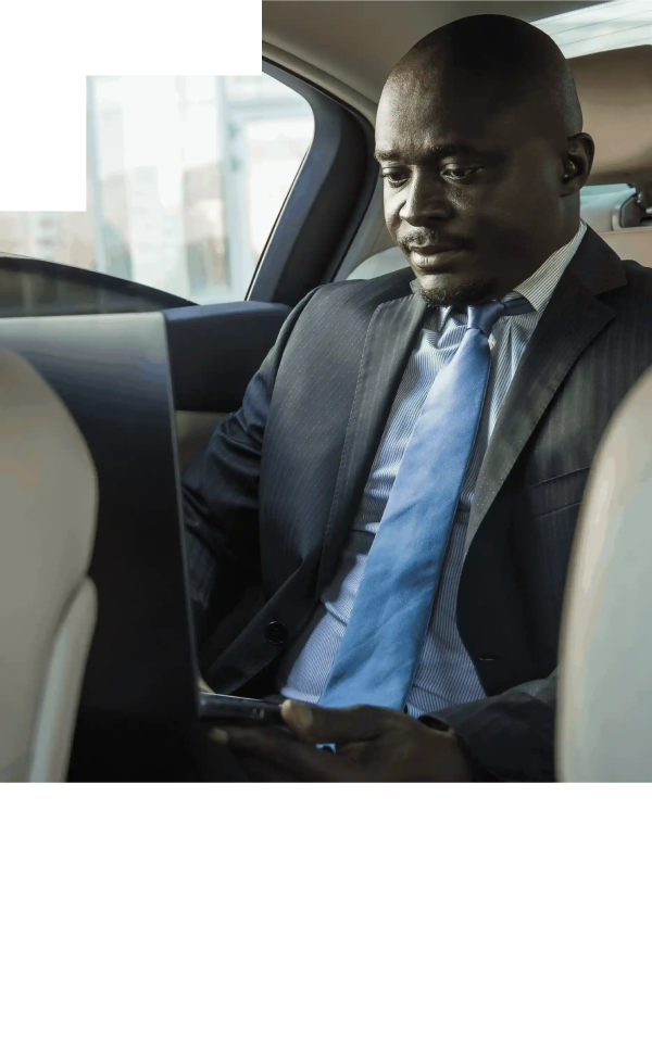 Handsome dark-skinned man in a suit smiling confidently while holding a digital tablet.